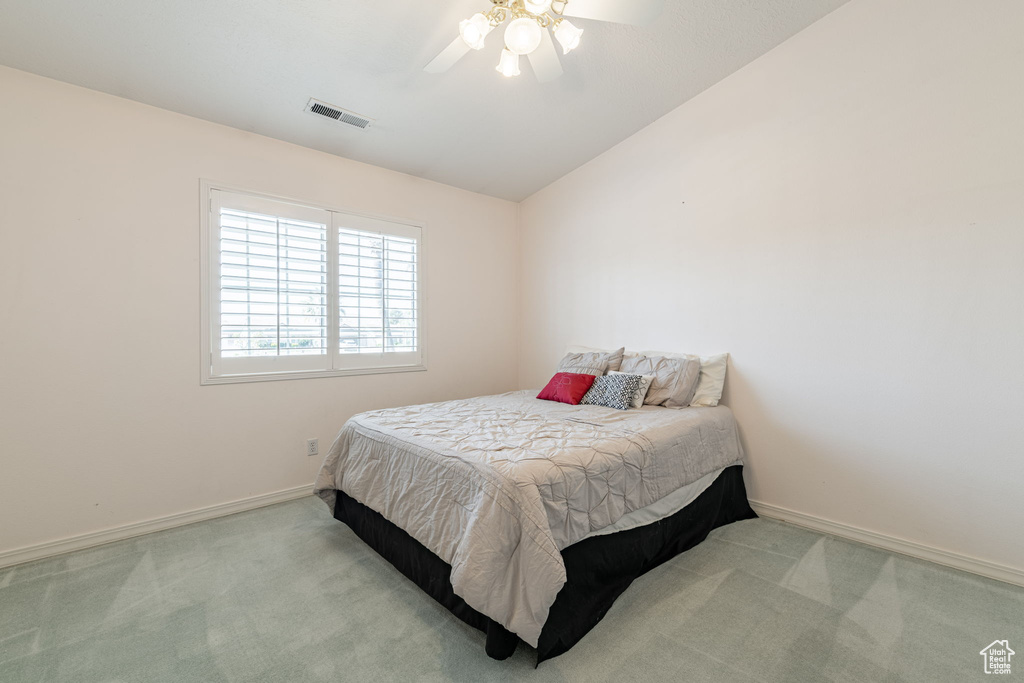 Carpeted bedroom with baseboards, ceiling fan, and lofted ceiling