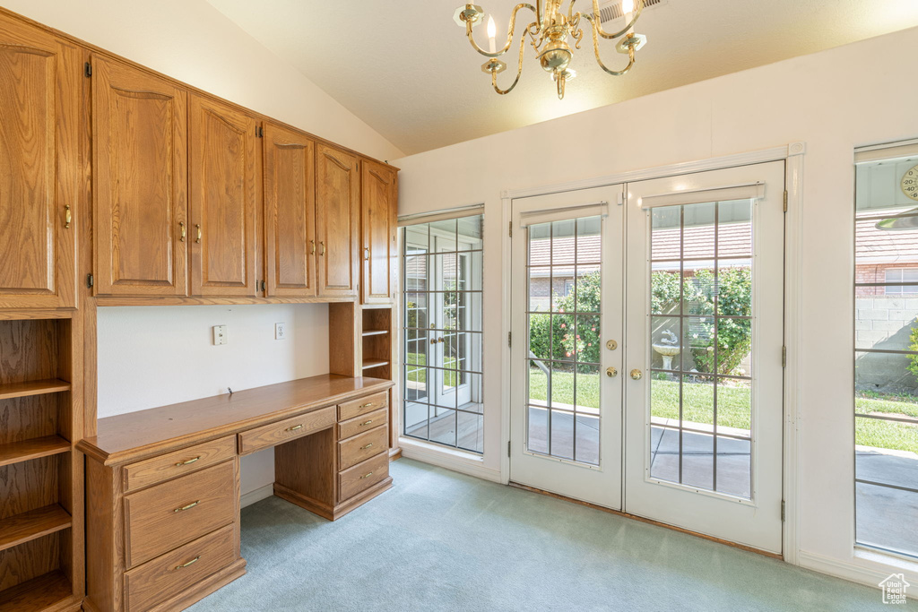 Unfurnished office with light carpet, lofted ceiling, built in study area, a chandelier, and french doors