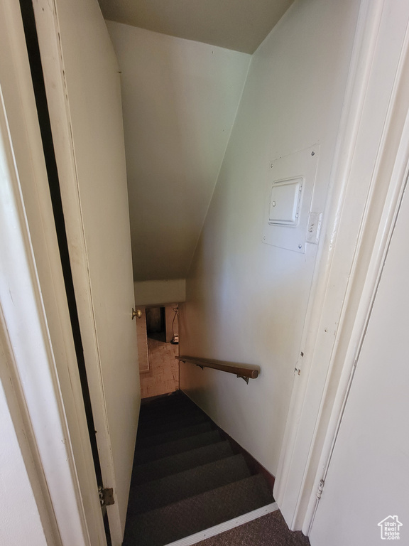Staircase with carpet and lofted ceiling