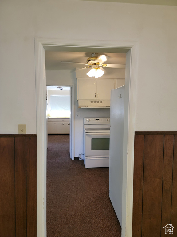 Hallway featuring dark carpet