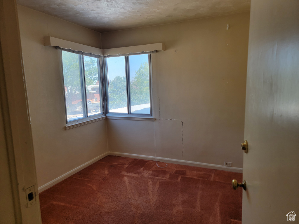 Unfurnished room featuring carpet floors, baseboards, and a textured ceiling