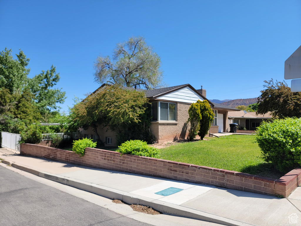 View of front of house featuring a chimney and brick siding
