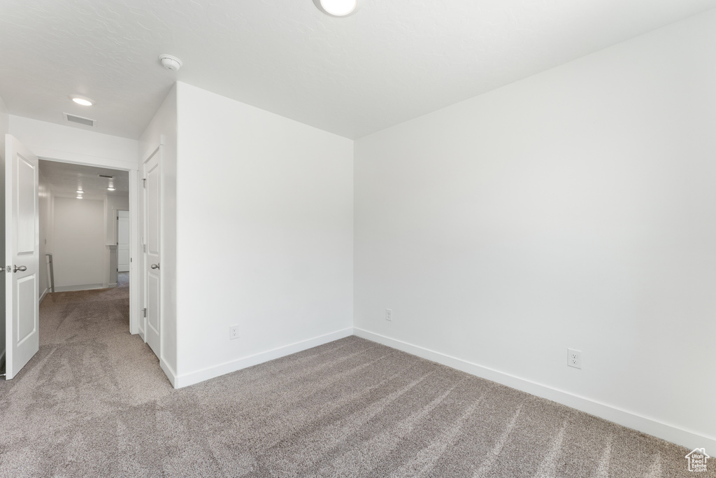 Carpeted empty room featuring baseboards