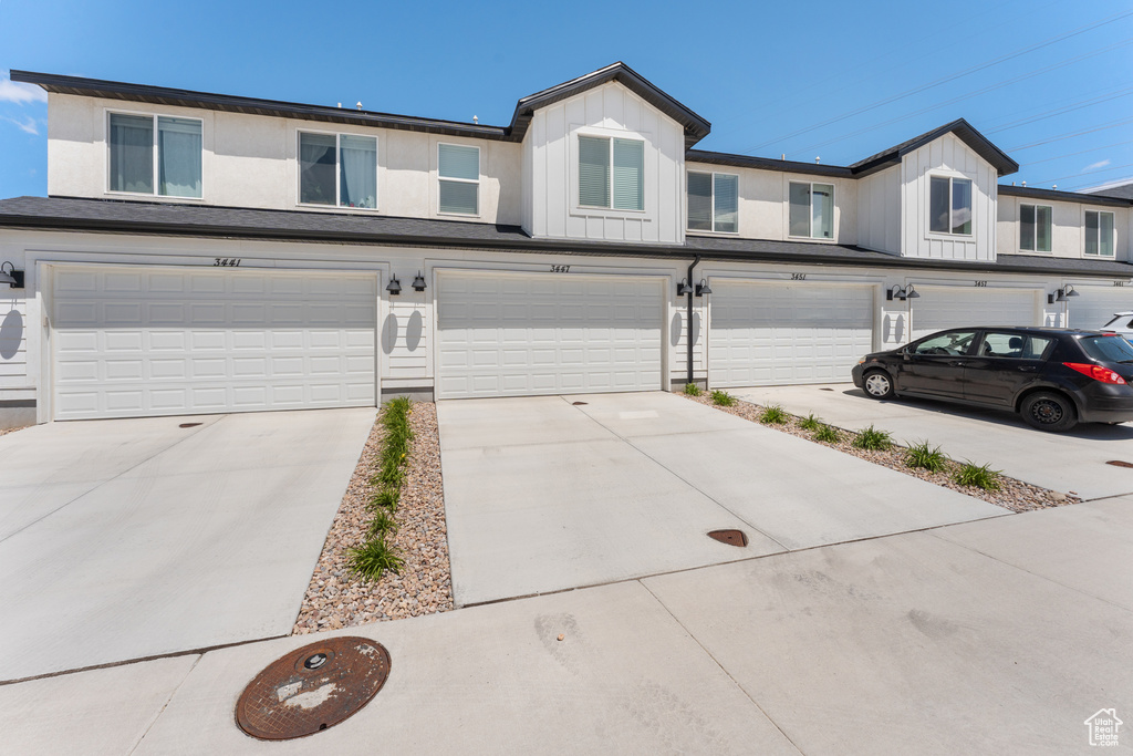 View of property featuring a garage, board and batten siding, and driveway