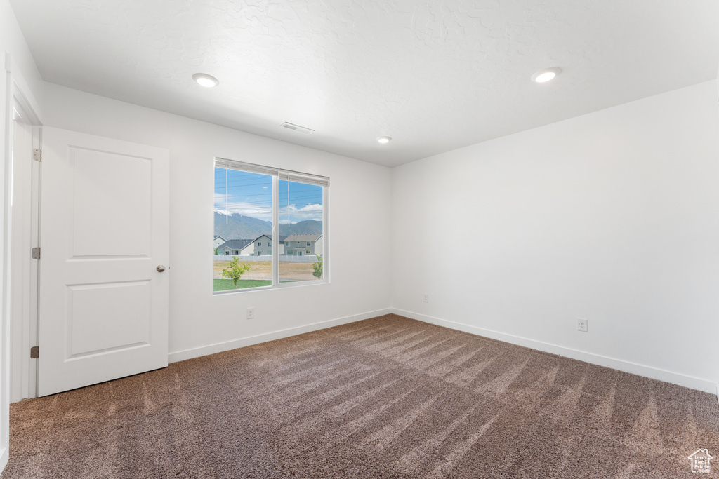 Spare room with carpet floors, baseboards, and recessed lighting