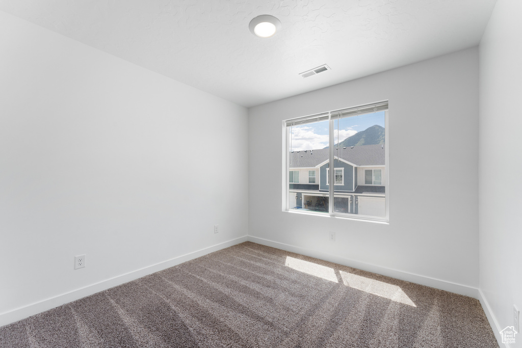 Carpeted spare room with baseboards