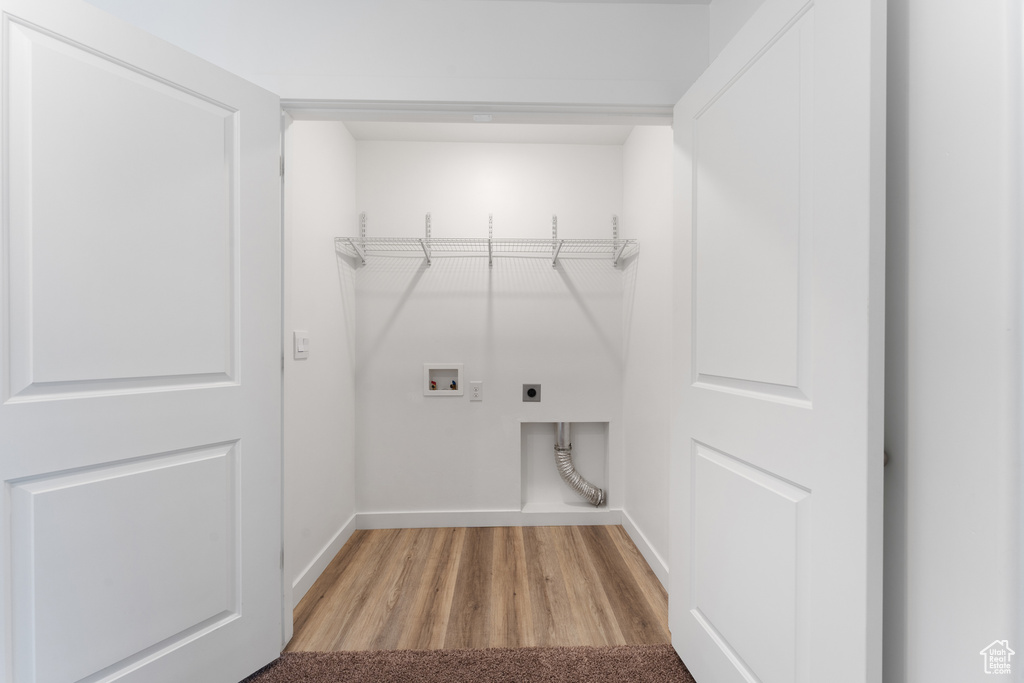 Laundry room featuring electric dryer hookup, washer hookup, wood finished floors, and baseboards