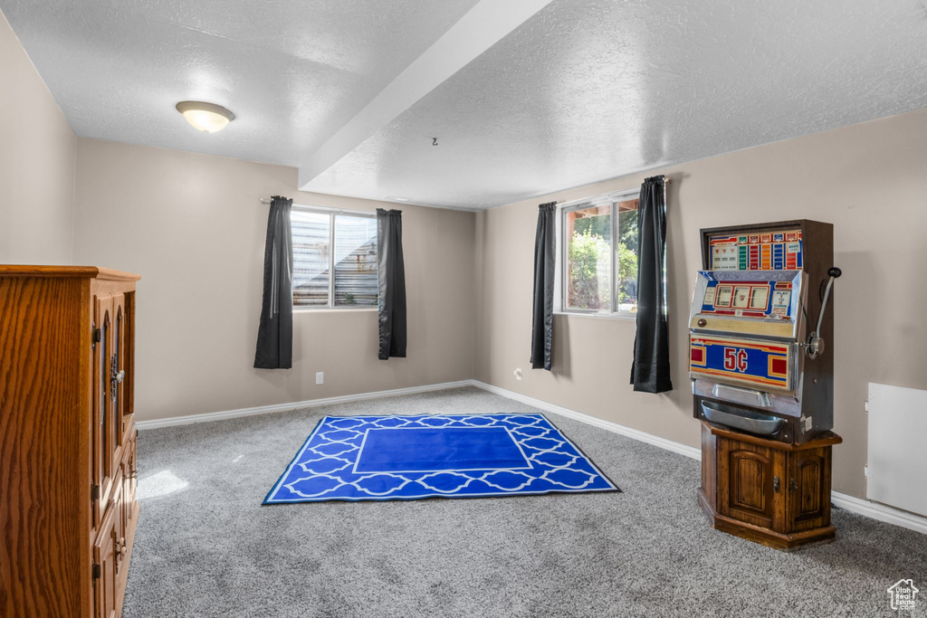 Interior space with carpet flooring, a textured ceiling, and baseboards