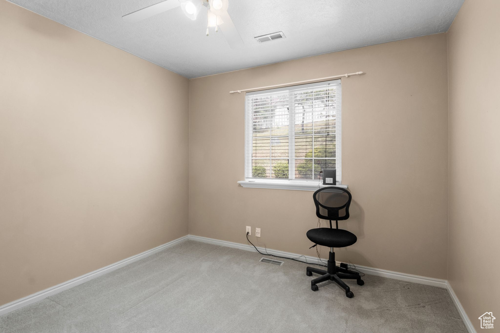Unfurnished office with carpet, a ceiling fan, and baseboards