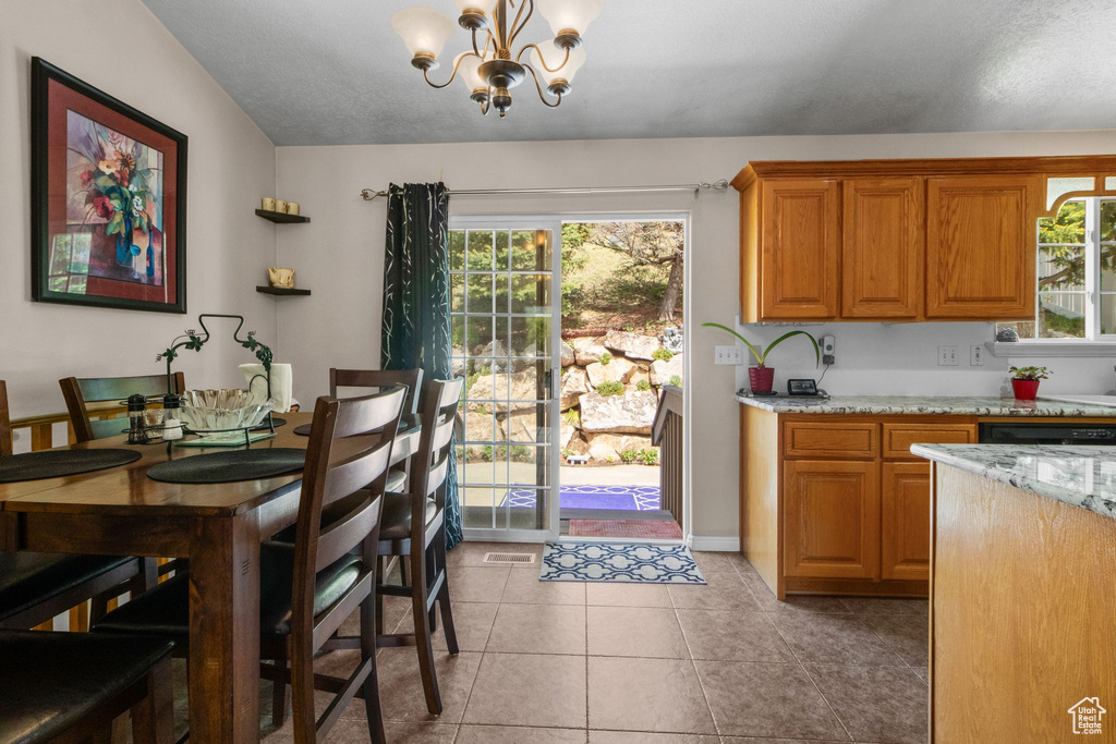 Dining space featuring a chandelier, healthy amount of natural light, and light tile patterned floors
