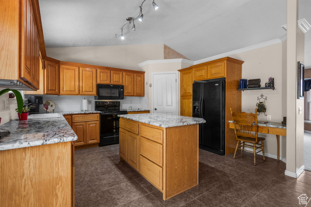 Kitchen featuring black appliances, lofted ceiling, a kitchen island, a sink, and light stone countertops