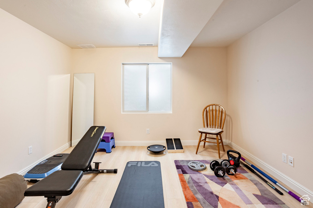 Workout area featuring wood finished floors and baseboards