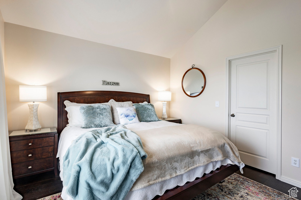 Bedroom featuring lofted ceiling and wood finished floors