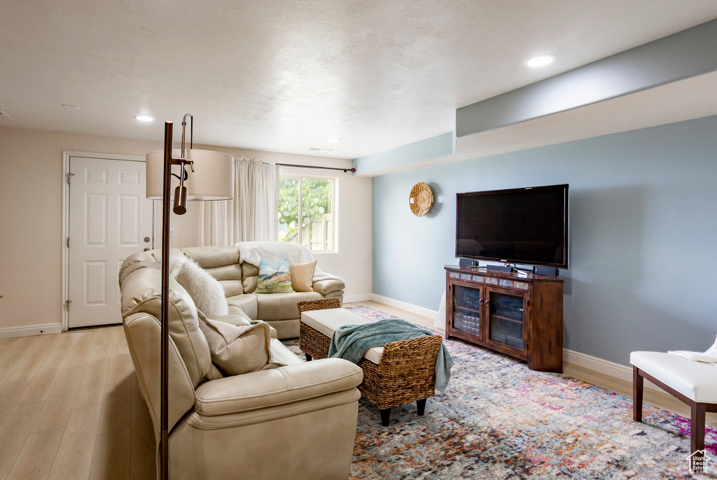 Living area with light wood-type flooring, baseboards, and recessed lighting