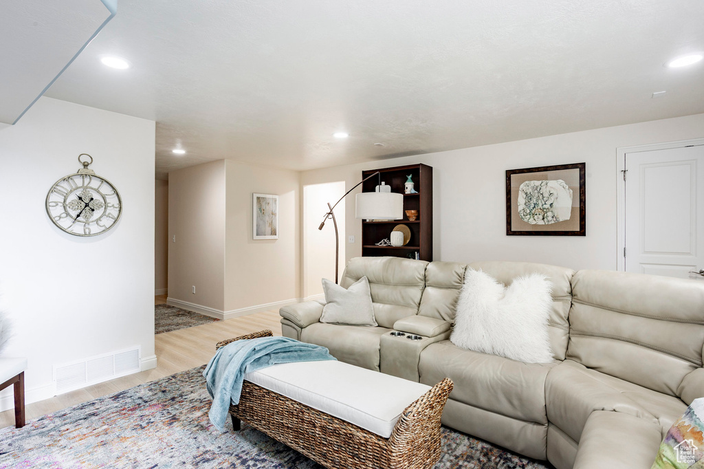 Living area featuring light wood finished floors, baseboards, and recessed lighting