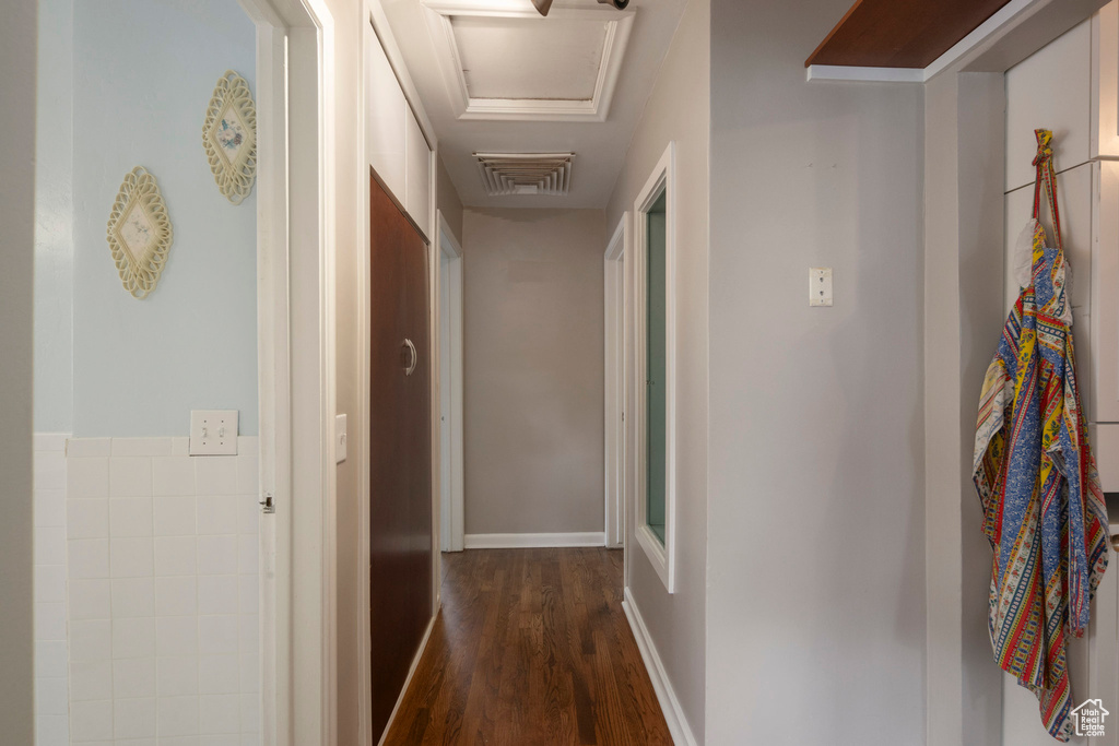 Corridor featuring attic access and dark wood-style flooring