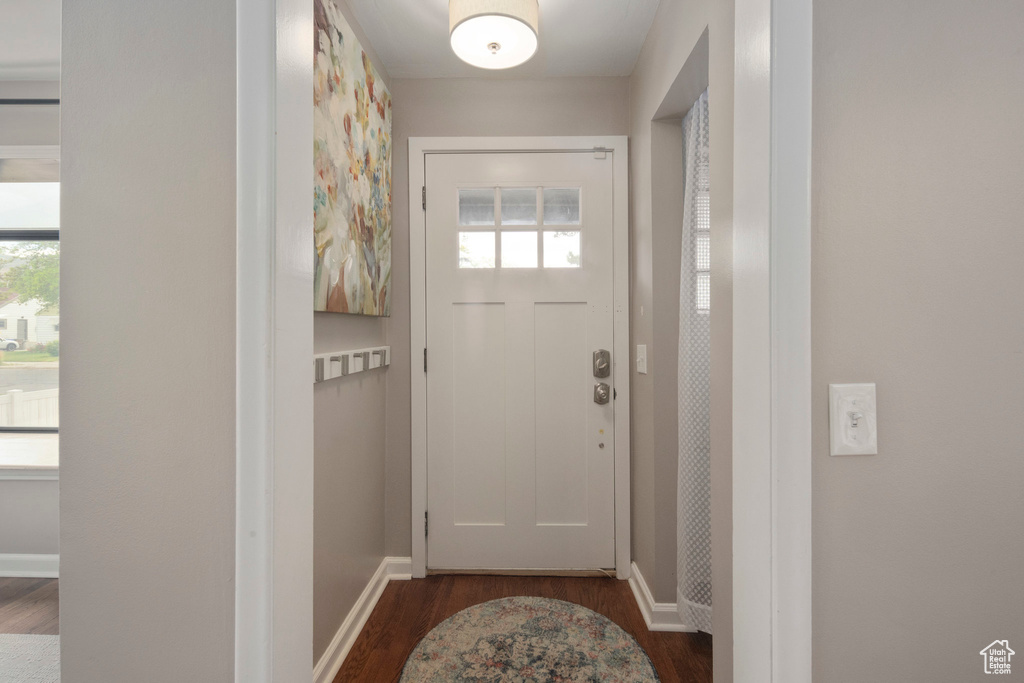 Foyer entrance featuring dark wood-type flooring and baseboards