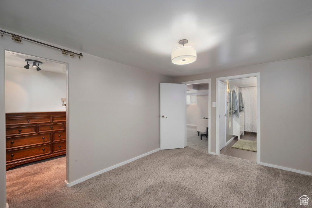 Unfurnished bedroom with carpet flooring, a spacious closet, a closet, and baseboards
