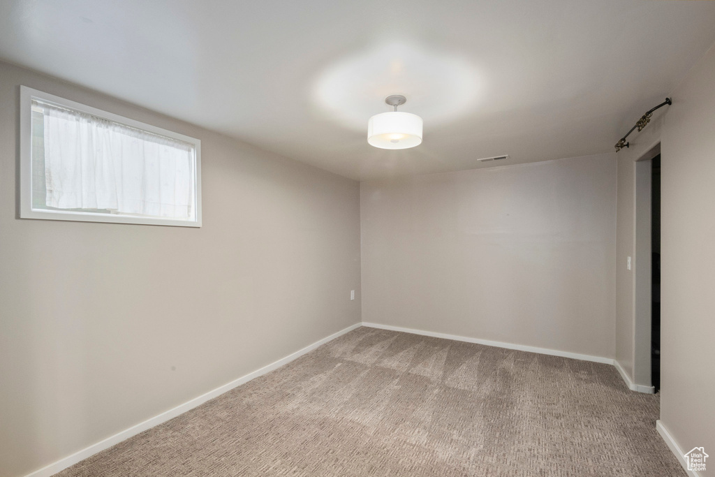 Empty room with light carpet and baseboards