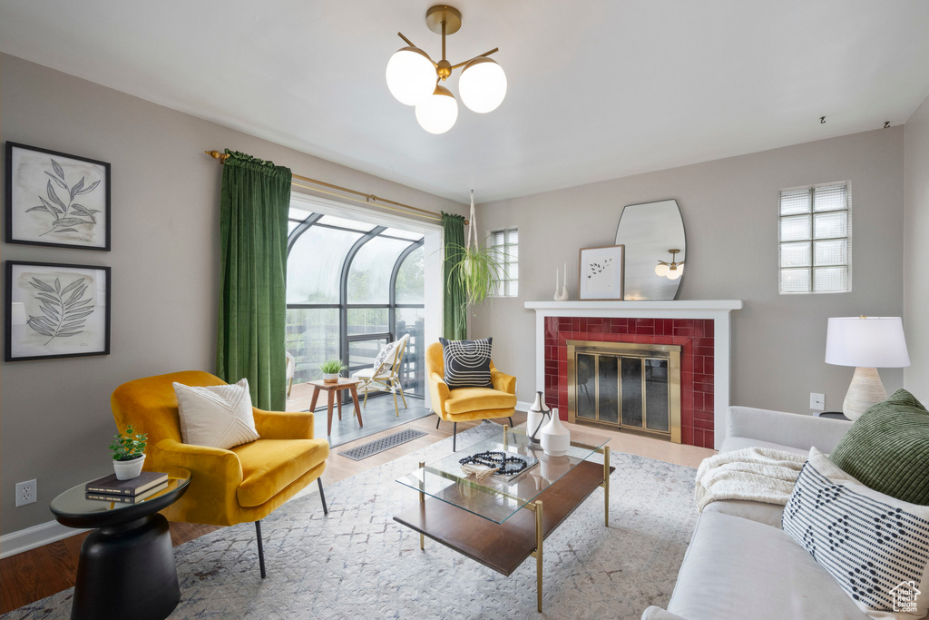 Living area with a chandelier, healthy amount of natural light, a brick fireplace, and baseboards