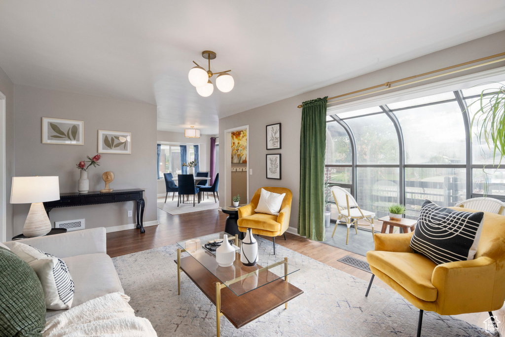 Living area featuring a chandelier, wood finished floors, and baseboards