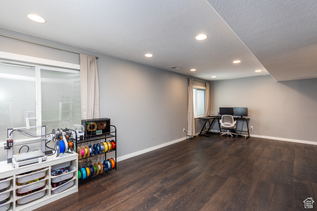 Home office with wood finished floors, baseboards, recessed lighting, and a textured ceiling