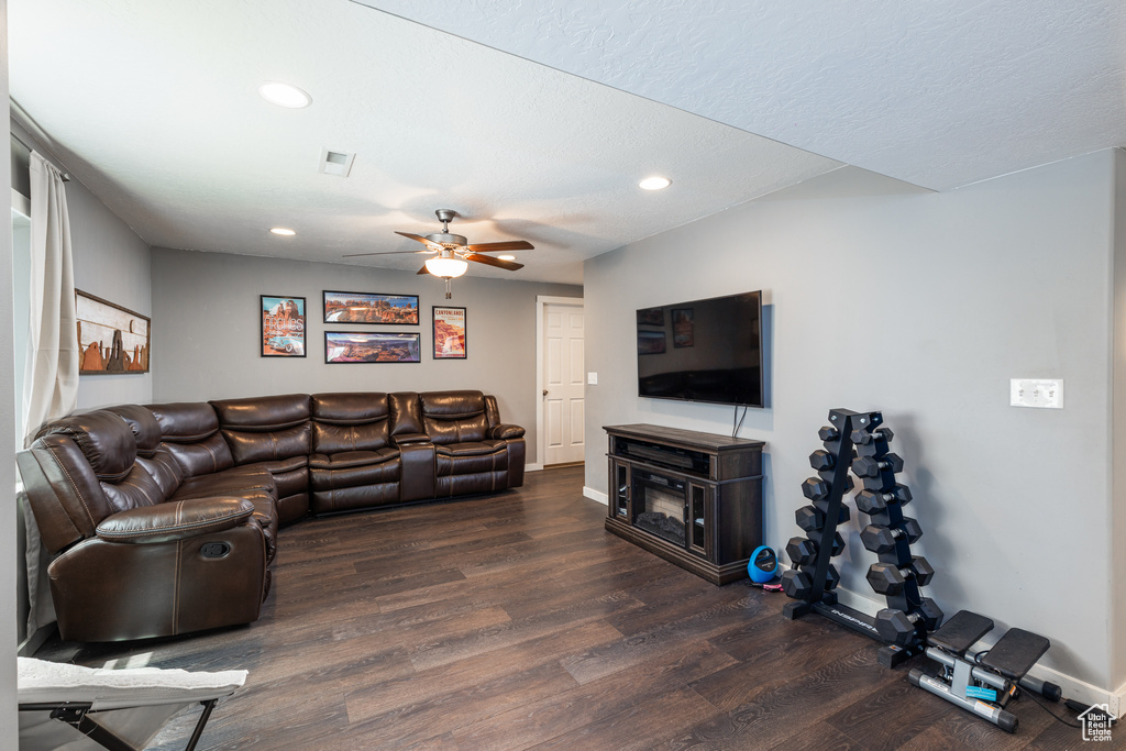 Living room with recessed lighting, wood finished floors, baseboards, and ceiling fan
