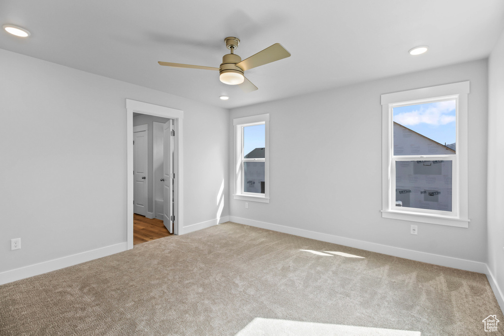 Unfurnished bedroom with carpet floors, baseboards, recessed lighting, ensuite bathroom, and a ceiling fan