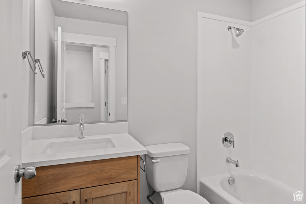 Full bath featuring toilet, vanity, and  shower combination