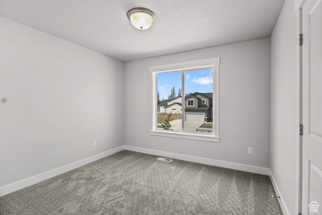 Unfurnished room featuring baseboards and carpet