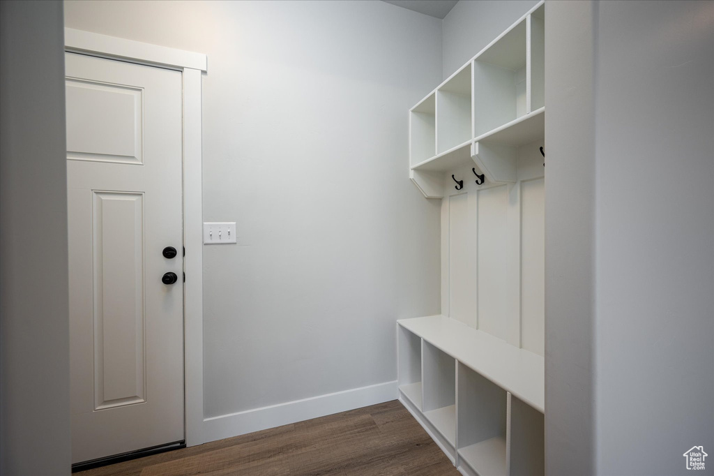Mudroom featuring dark wood finished floors and baseboards
