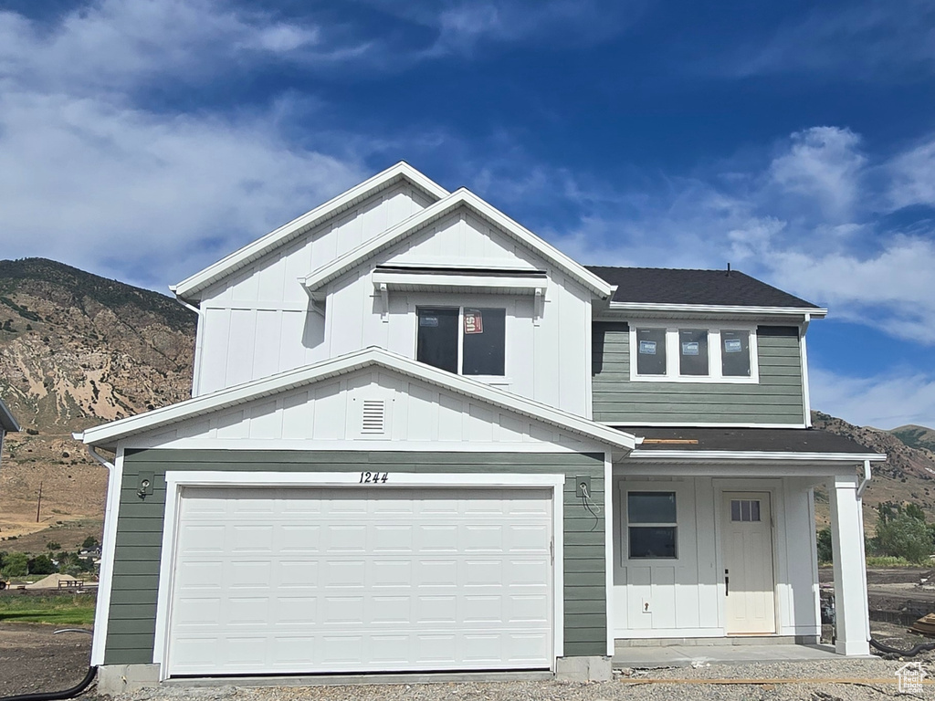 View of front of house featuring a mountain view and gravel driveway