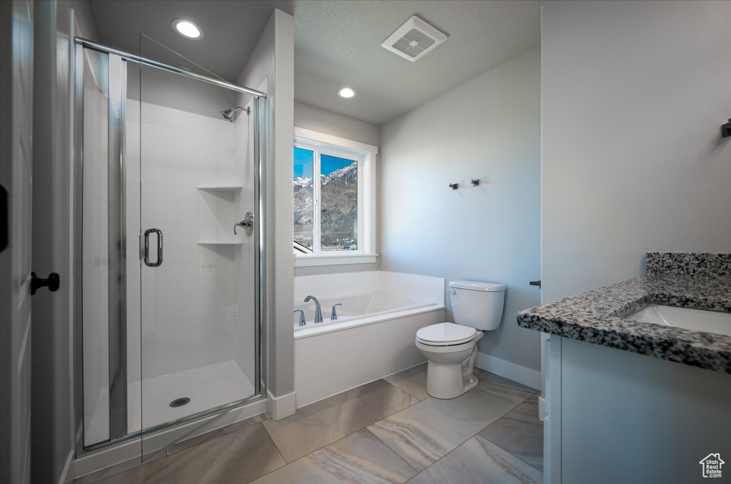 Bathroom featuring a shower stall, a bath, toilet, recessed lighting, and vanity