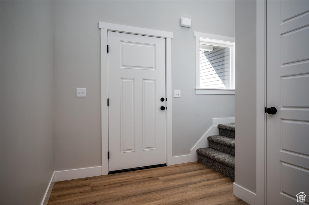 Entryway with wood finished floors, baseboards, and stairs