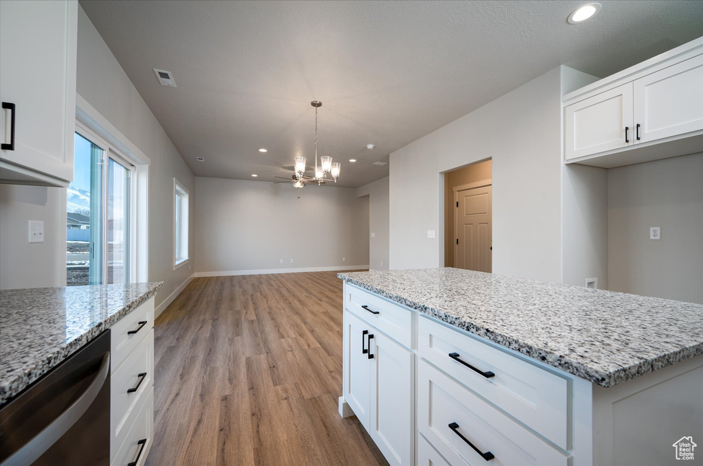 Kitchen with a chandelier, light wood-style flooring, recessed lighting, light stone counters, and white cabinetry