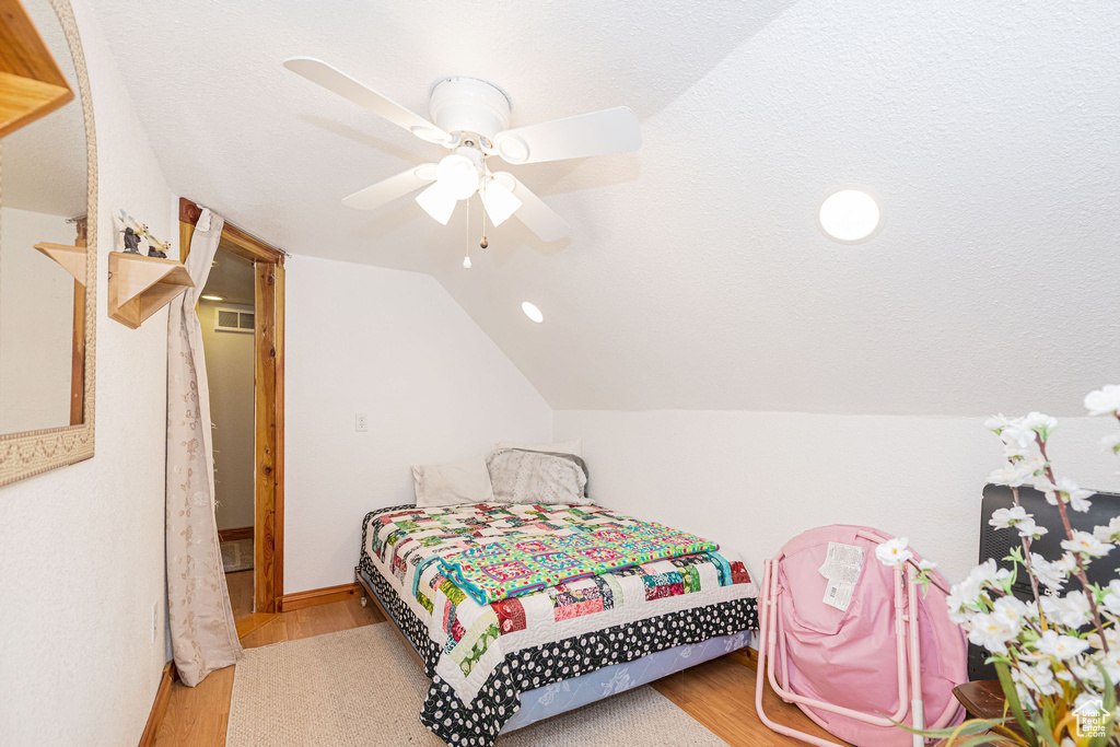 Bedroom featuring wood finished floors, vaulted ceiling, a ceiling fan, baseboards, and recessed lighting
