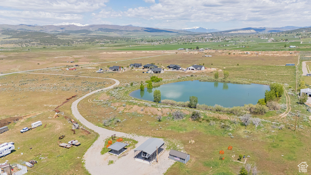 Aerial view of property and surrounding area with a water and mountain view