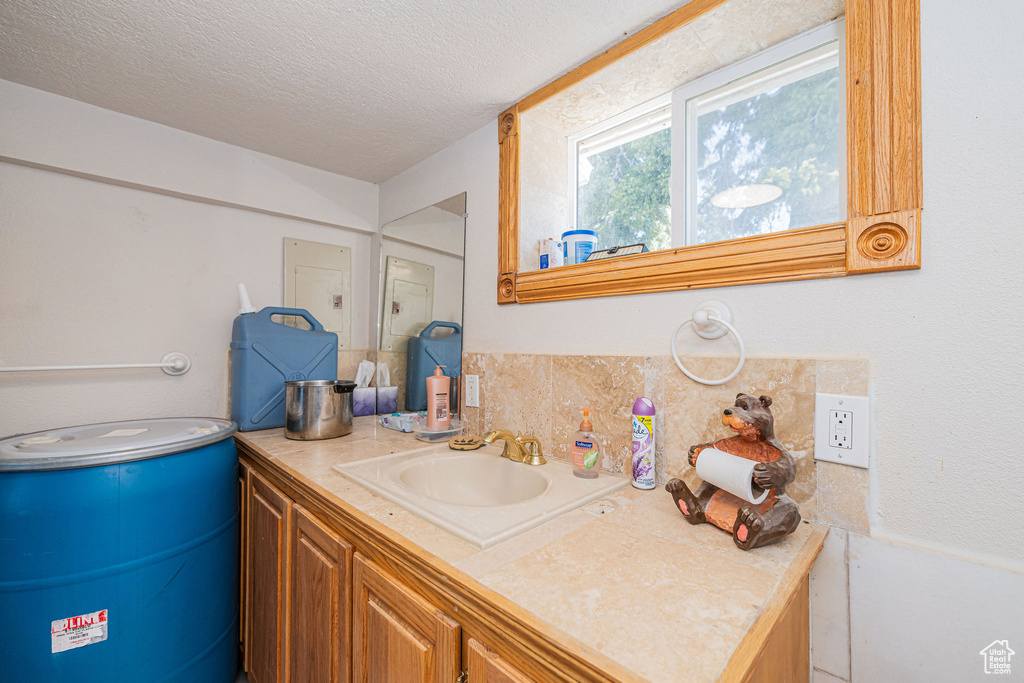Bathroom featuring a textured ceiling and vanity