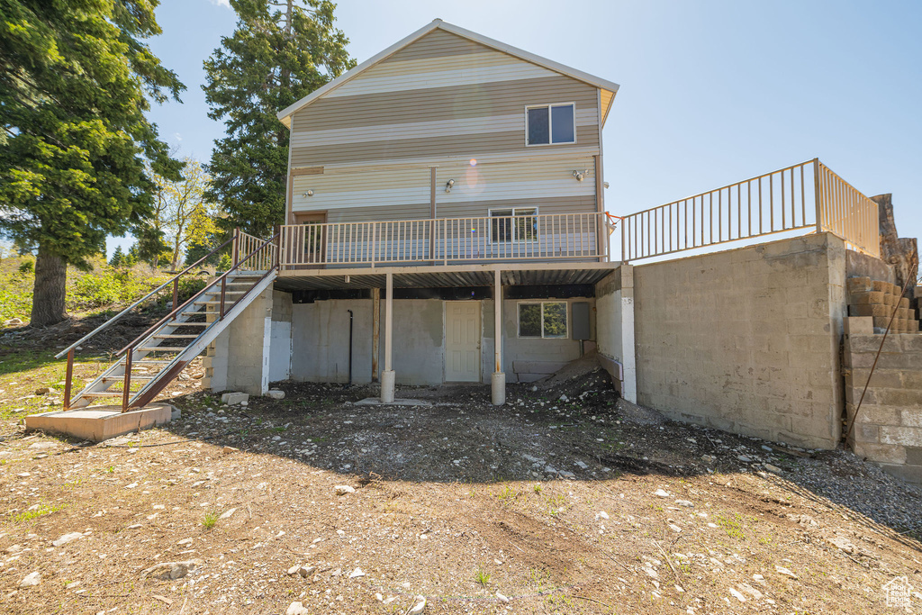 Back of house with stairway and a wooden deck