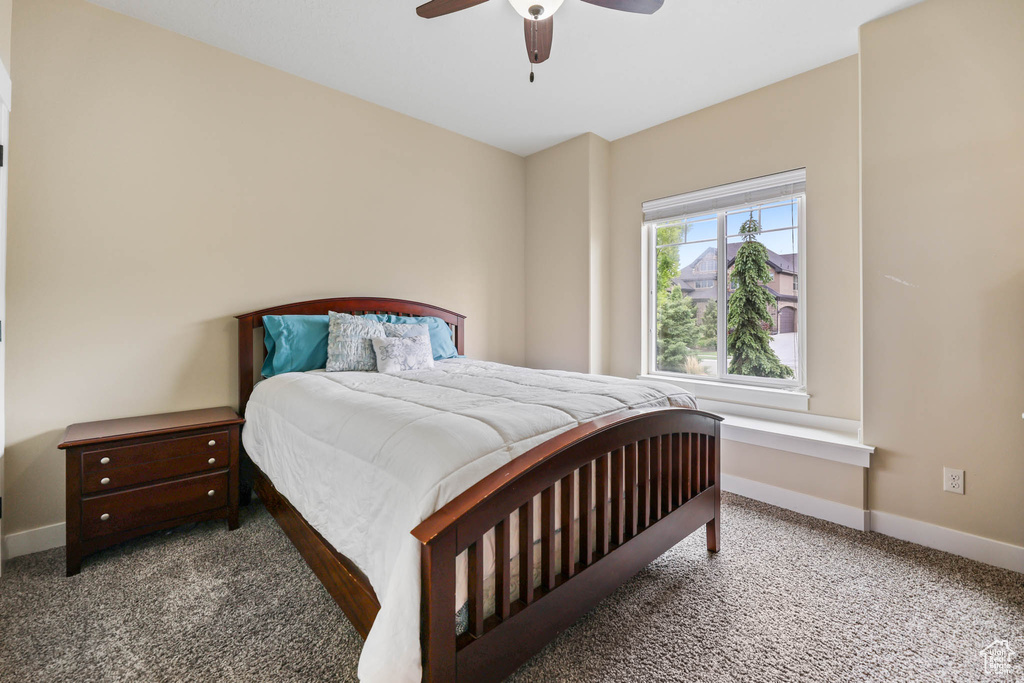 Carpeted bedroom featuring baseboards and ceiling fan