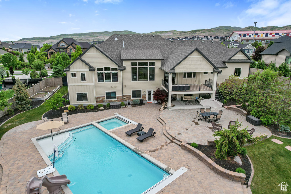 View of swimming pool featuring a patio area, a mountain view, a residential view, and a pool with connected hot tub