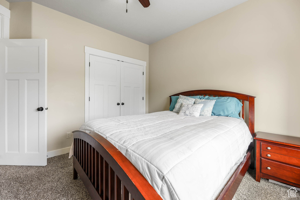 Carpeted bedroom with baseboards, a closet, and ceiling fan