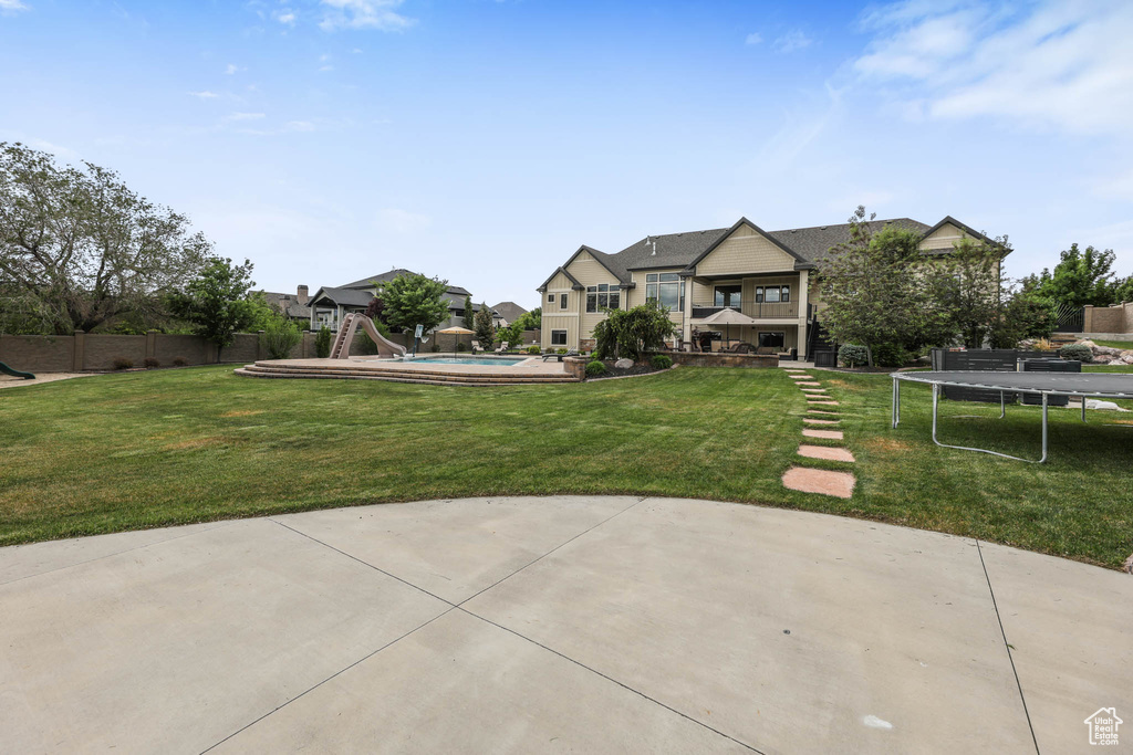 View of yard featuring a trampoline and a patio area