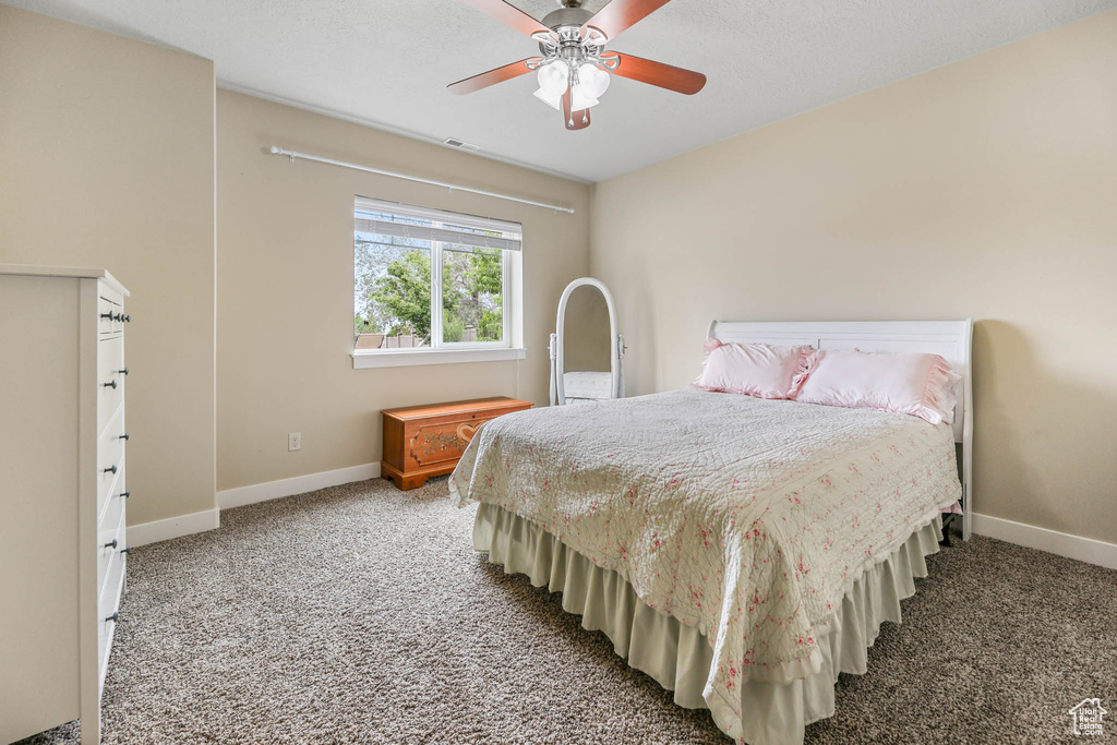 Carpeted bedroom with baseboards and ceiling fan