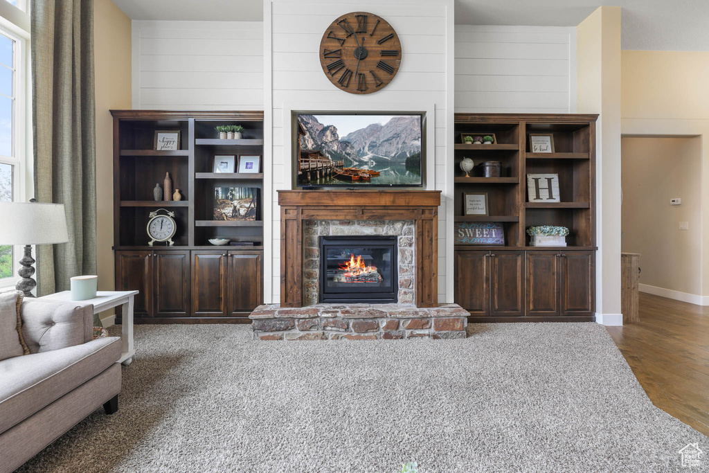 Living room featuring a glass covered fireplace, wood finished floors, and baseboards