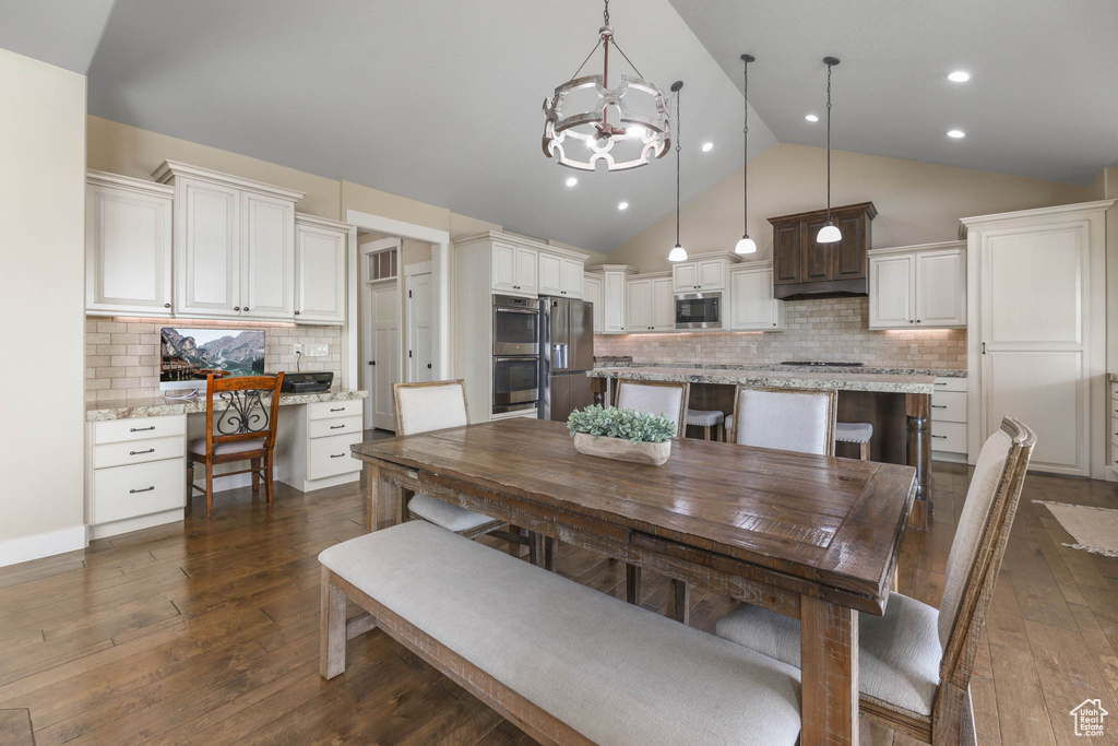 Dining area featuring a chandelier, dark wood-style flooring, recessed lighting, and high vaulted ceiling