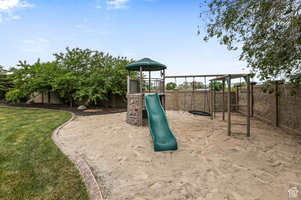 View of play area with a fenced backyard