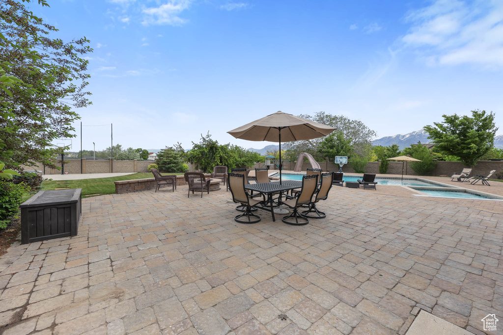 Fenced backyard with a patio area, a mountain view, and an outdoor hot tub
