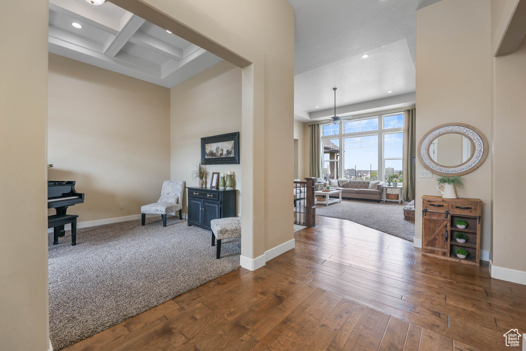 Corridor featuring recessed lighting, a towering ceiling, baseboards, hardwood / wood-style flooring, and beamed ceiling