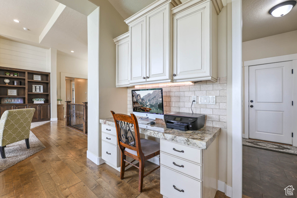 Home office featuring built in study area, dark wood finished floors, baseboards, and recessed lighting